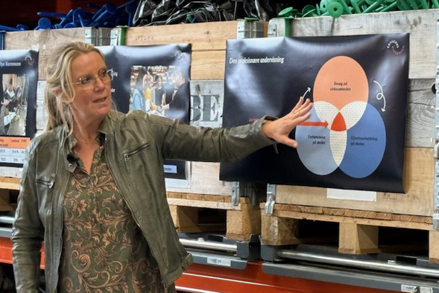 Pernille Peiter viser planche om samarbejdet mellem skoler og virksomheder i erhvervsrygsækken